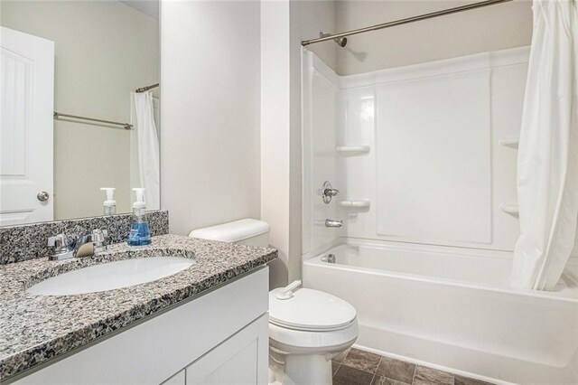 bathroom featuring toilet, shower / bath combo, and vanity