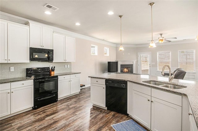 kitchen with tasteful backsplash, visible vents, dark wood-style flooring, black appliances, and a sink