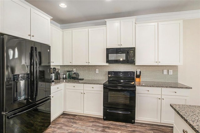 kitchen featuring tasteful backsplash, white cabinets, dark wood-style floors, light stone counters, and black appliances