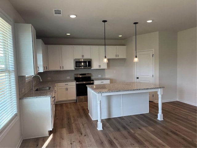 57 Longhorn Way, Auburn, GA 30011 - kitchen with appliances with stainless steel finishes, a sink, light stone countertops, dark wood-style flooring, and white cabinetry