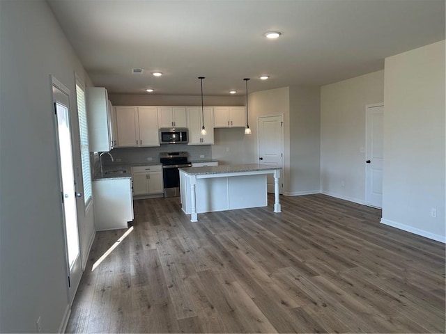 57 Longhorn Way, Auburn, GA 30011 - kitchen featuring stainless steel appliances, a sink, wood finished floors, white cabinets, and recessed lighting