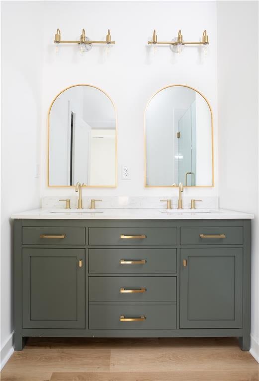 bathroom featuring hardwood / wood-style flooring, vanity, and a shower with shower door