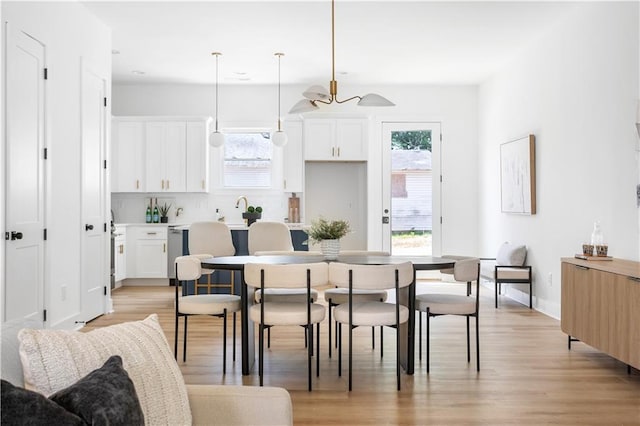 dining room with plenty of natural light, ceiling fan, and light wood-type flooring