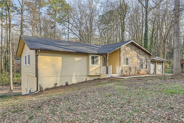 view of front of property featuring a garage and stone siding