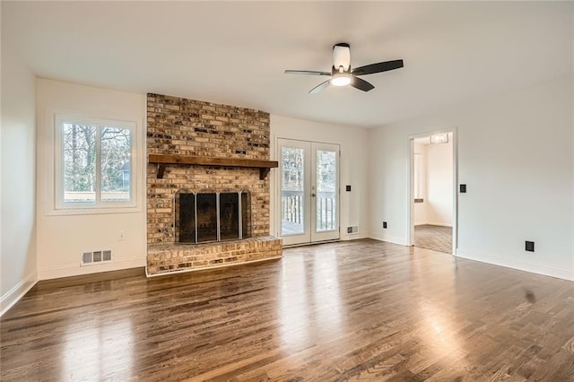 unfurnished living room featuring a wealth of natural light, visible vents, ceiling fan, and wood finished floors