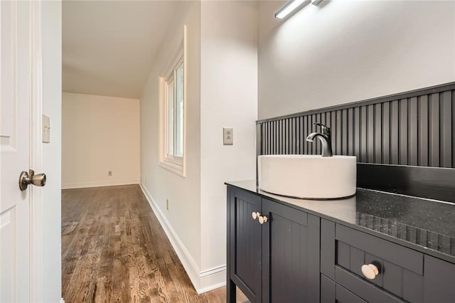 bathroom featuring vanity, baseboards, and wood finished floors