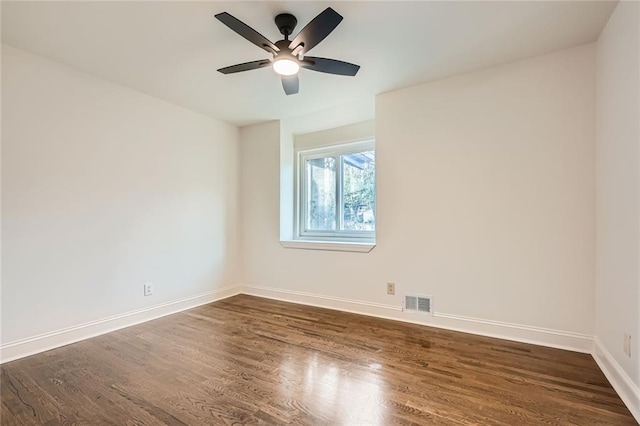 unfurnished room with dark wood finished floors, baseboards, visible vents, and ceiling fan