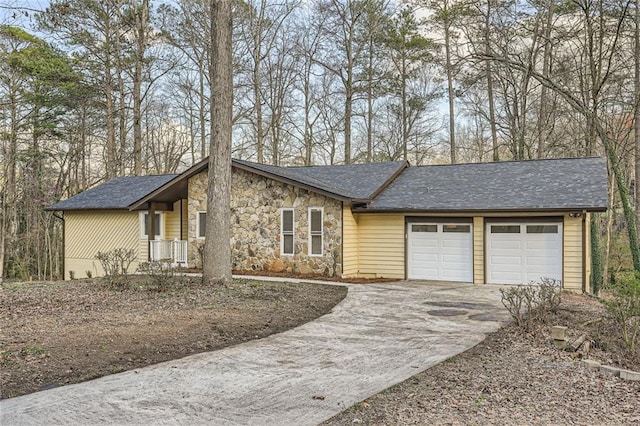 view of front facade featuring a garage, stone siding, concrete driveway, and a shingled roof