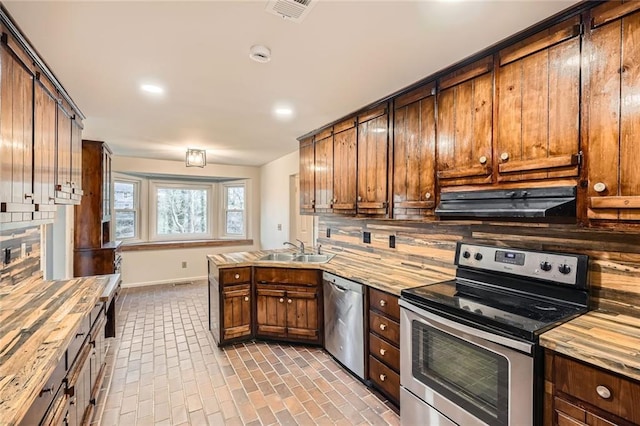 kitchen featuring tasteful backsplash, ventilation hood, stainless steel appliances, and a sink