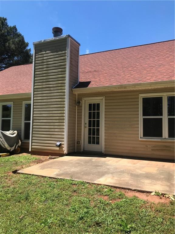75 Oak Hill Dr, Covington, GA 30016 - back of property with a patio area, roof with shingles, a chimney, and a yard