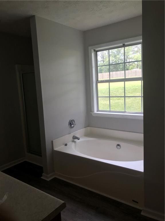 75 Oak Hill Dr, Covington, GA 30016 - full bathroom with a garden tub, wood finished floors, and a textured ceiling