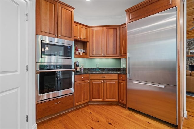 74 Cherokee Way, Big Canoe, GA 30143 - kitchen with built in appliances, brown cabinetry, dark stone countertops, and light wood-style flooring