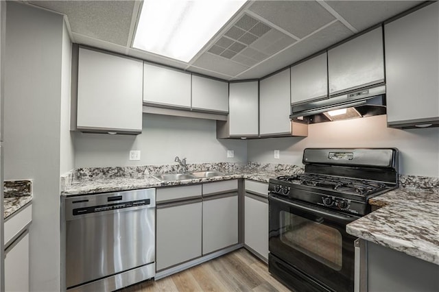 kitchen featuring dishwasher, black range with gas cooktop, under cabinet range hood, a sink, and light wood finished floors
