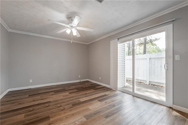 spare room featuring wood finished floors, a ceiling fan, baseboards, a textured ceiling, and ornamental molding