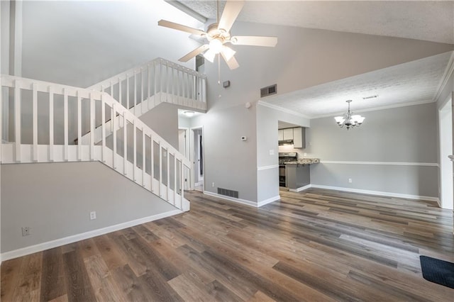 unfurnished living room with a chandelier, a ceiling fan, stairs, baseboards, and wood finished floors
