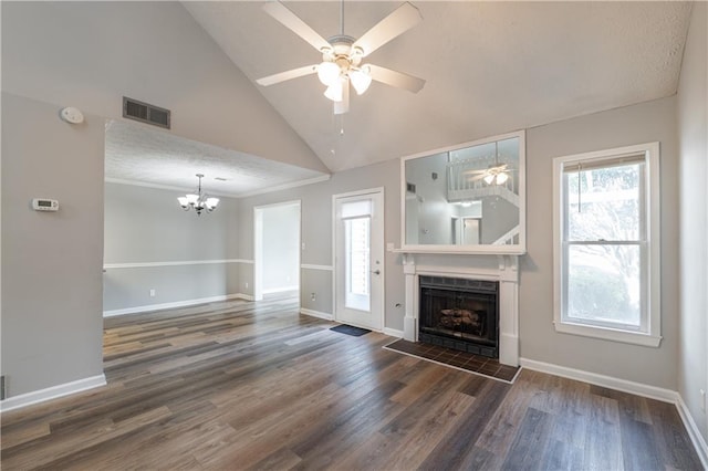 unfurnished living room with a ceiling fan, healthy amount of natural light, a chandelier, a tile fireplace, and high vaulted ceiling