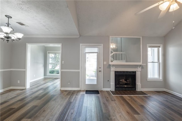 unfurnished living room featuring a fireplace with flush hearth, healthy amount of natural light, wood finished floors, a chandelier, and a textured ceiling