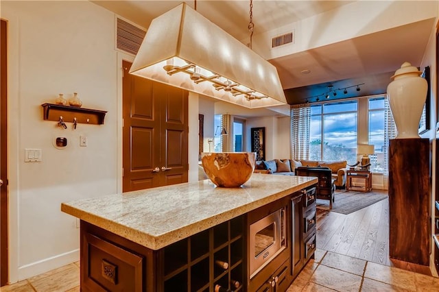 1820 Peachtree St NW Unit 811, Atlanta, GA 30309 - kitchen featuring stainless steel microwave, a kitchen island, open floor plan, and baseboards
