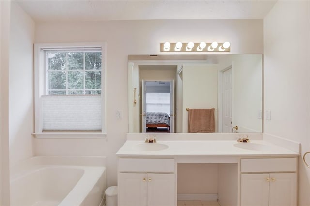 ensuite bathroom featuring a garden tub and double vanity
