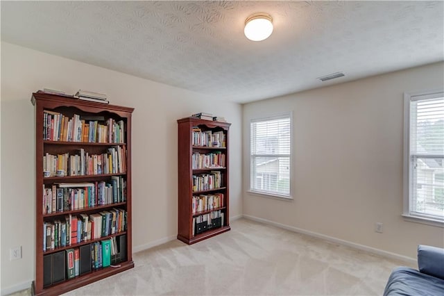 sitting room featuring plenty of natural light, carpet flooring, a textured ceiling, and baseboards