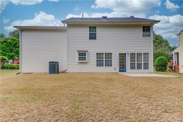 rear view of property featuring a yard, a patio area, and central air condition unit