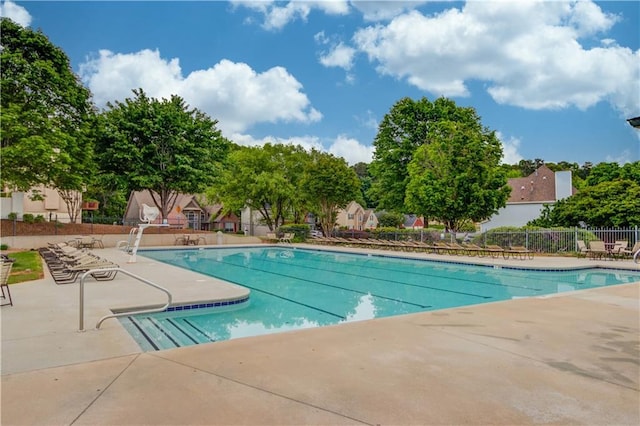 community pool with fence and a patio