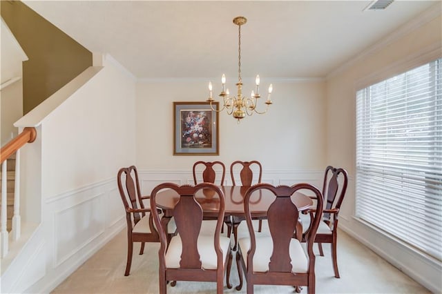 dining room featuring light carpet, a chandelier, wainscoting, stairway, and ornamental molding
