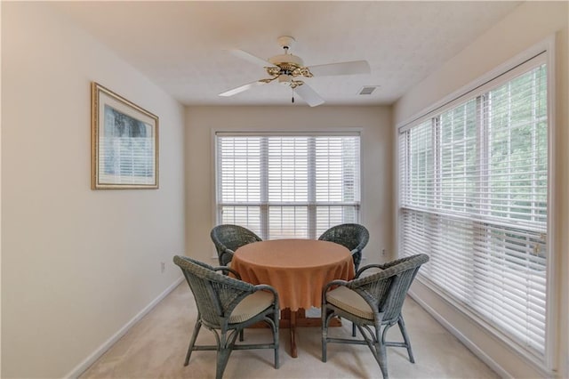 dining space with baseboards, ceiling fan, healthy amount of natural light, and light carpet