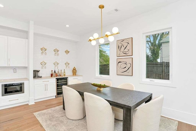1598 Athens Ave, Atlanta, GA 30310 - dining area with indoor bar, wine cooler, a chandelier, light wood-style floors, and visible vents