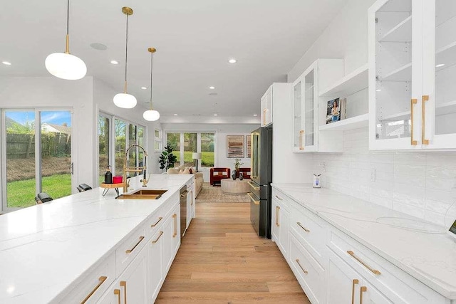 1598 Athens Ave, Atlanta, GA 30310 - kitchen featuring light wood-type flooring, backsplash, a sink, freestanding refrigerator, and light stone countertops