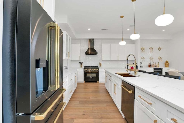 1598 Athens Ave, Atlanta, GA 30310 - kitchen featuring white cabinets, wall chimney exhaust hood, stainless steel appliances, a sink, and light wood-style floors