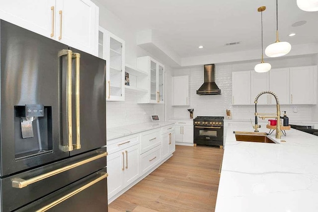 1598 Athens Ave, Atlanta, GA 30310 - kitchen with high end black range oven, stainless steel fridge, wall chimney exhaust hood, a sink, and light wood-type flooring