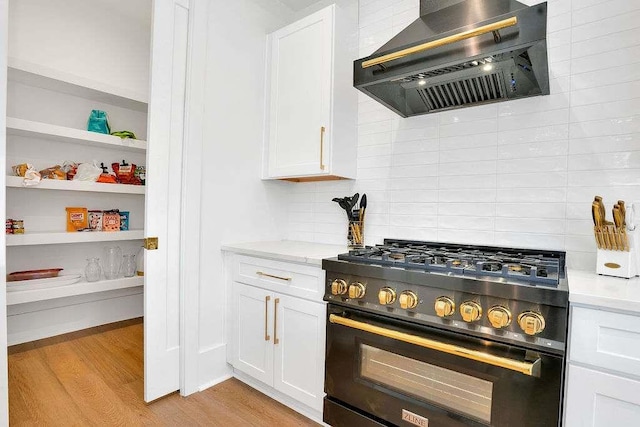 1598 Athens Ave, Atlanta, GA 30310 - kitchen featuring light wood finished floors, wall chimney exhaust hood, white cabinets, and high end black range oven