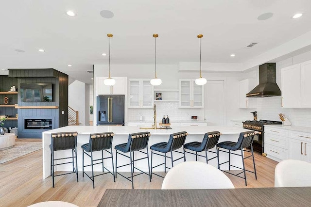1598 Athens Ave, Atlanta, GA 30310 - kitchen featuring a sink, stainless steel range, wall chimney exhaust hood, black refrigerator with ice dispenser, and visible vents
