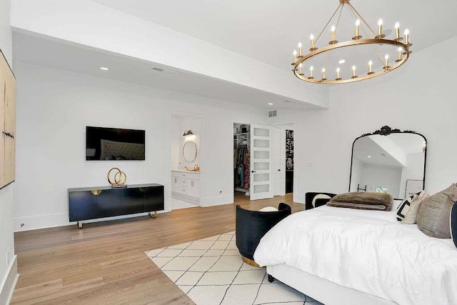 1598 Athens Ave, Atlanta, GA 30310 - bedroom with light wood finished floors, a spacious closet, ensuite bathroom, baseboards, and an inviting chandelier
