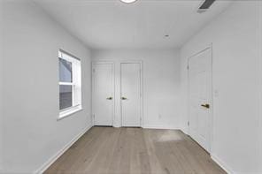 unfurnished room with light wood finished floors and baseboards