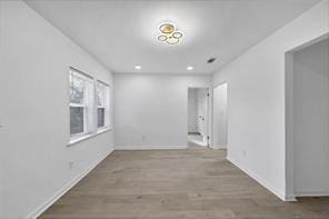 spare room featuring baseboards, wood finished floors, and recessed lighting