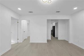 empty room featuring light wood-style flooring, baseboards, and recessed lighting