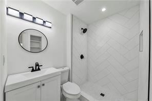 full bath featuring toilet, a shower stall, visible vents, and vanity