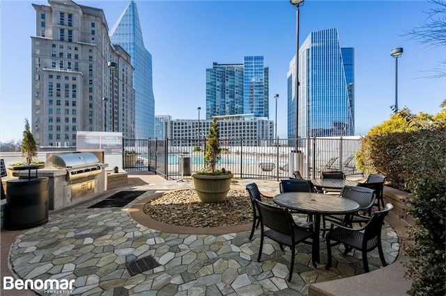 view of patio / terrace with an outdoor kitchen, a fenced in pool, and grilling area