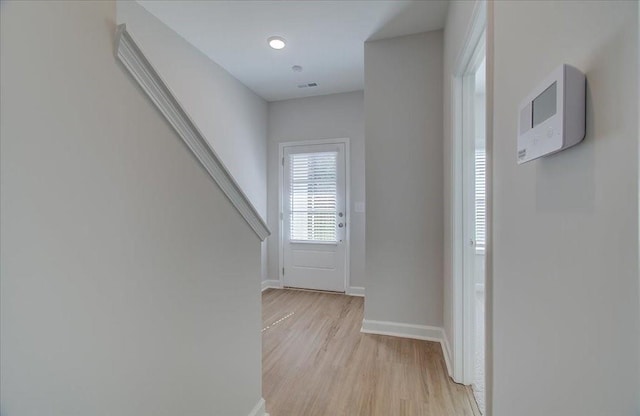 interior space with light wood-style floors, visible vents, stairs, and baseboards