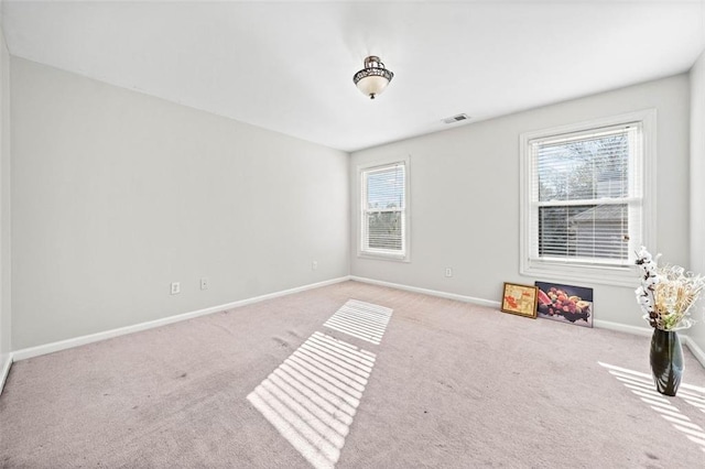 unfurnished room featuring light carpet