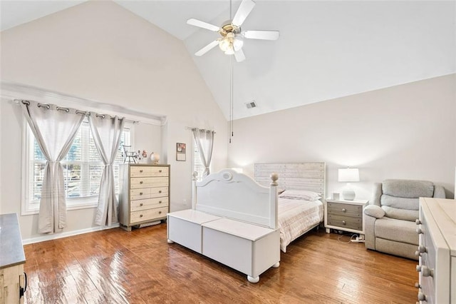 bedroom with wood-type flooring, ceiling fan, and high vaulted ceiling