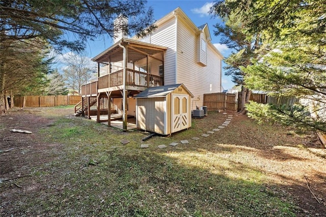 back of house featuring a wooden deck, a shed, and central air condition unit