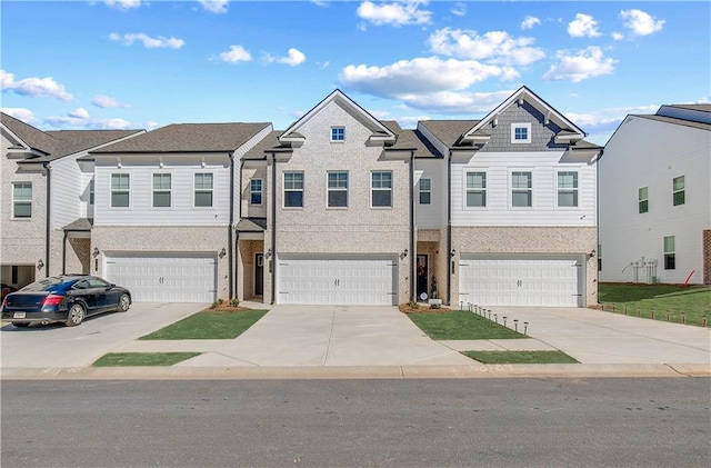 multi unit property with an attached garage, a residential view, and concrete driveway