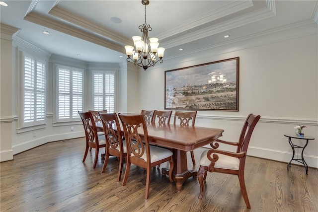 dining room featuring wood-type flooring, a tray ceiling, a chandelier, and ornamental molding