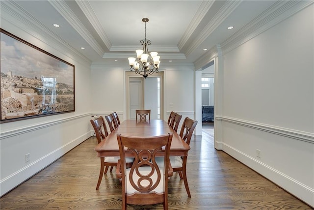 dining area featuring ornamental molding, a notable chandelier, wood-type flooring, and a raised ceiling