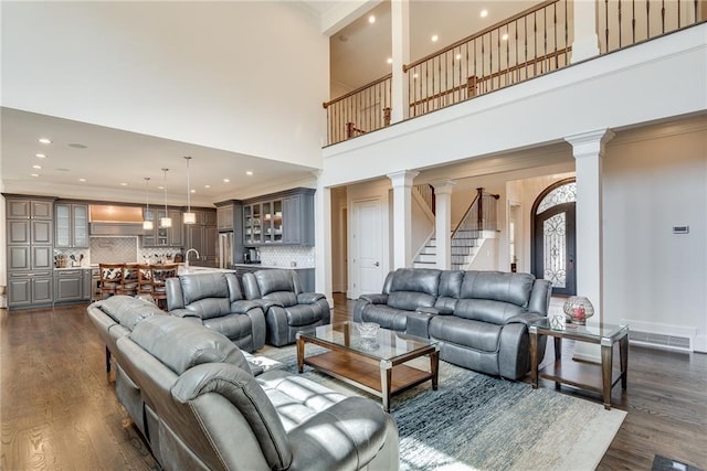 living room featuring a high ceiling, crown molding, and dark hardwood / wood-style flooring