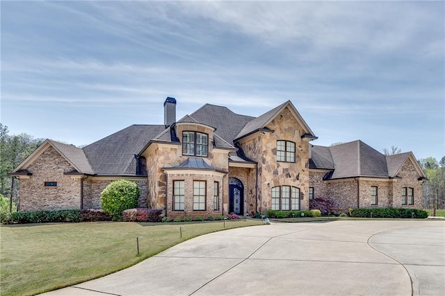 french country inspired facade with a front yard