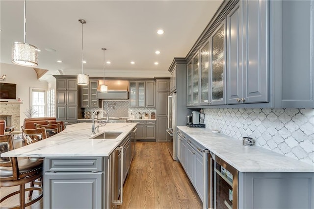 kitchen featuring sink, light stone counters, decorative light fixtures, and backsplash